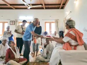 2. Sri Ganga Maa being presented with the first copy of the newly published Silent Presence, Vol. 1, by the editor, David Godman.